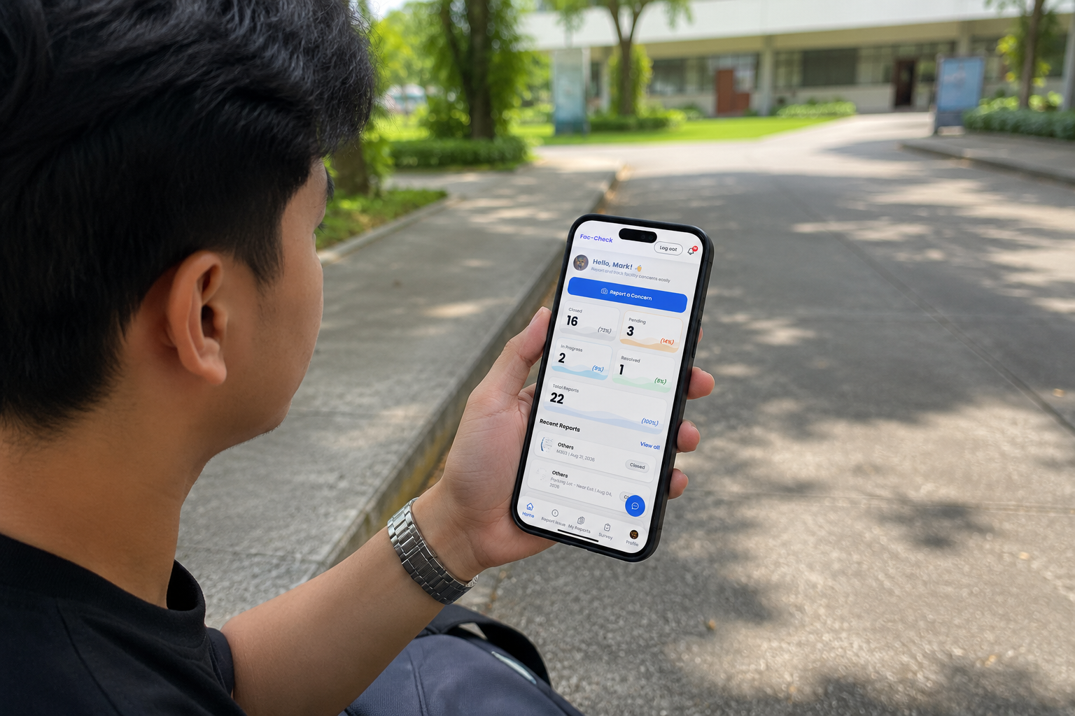 A student checking the status of their reports in the Fac-Check app on a phone, outdoors on campus.